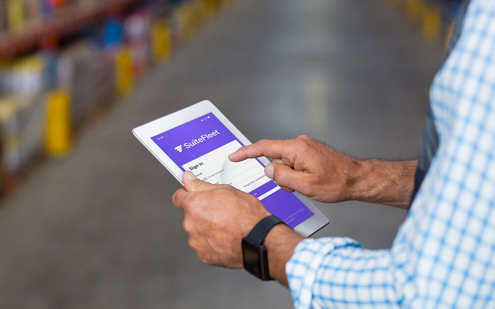 Logistics planner holding a tablet to sign in SuiteFleetlast-mile delivery system