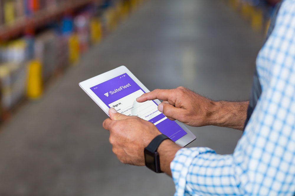 Logistics planner holding a tablet to sign in SuiteFleetlast-mile delivery system