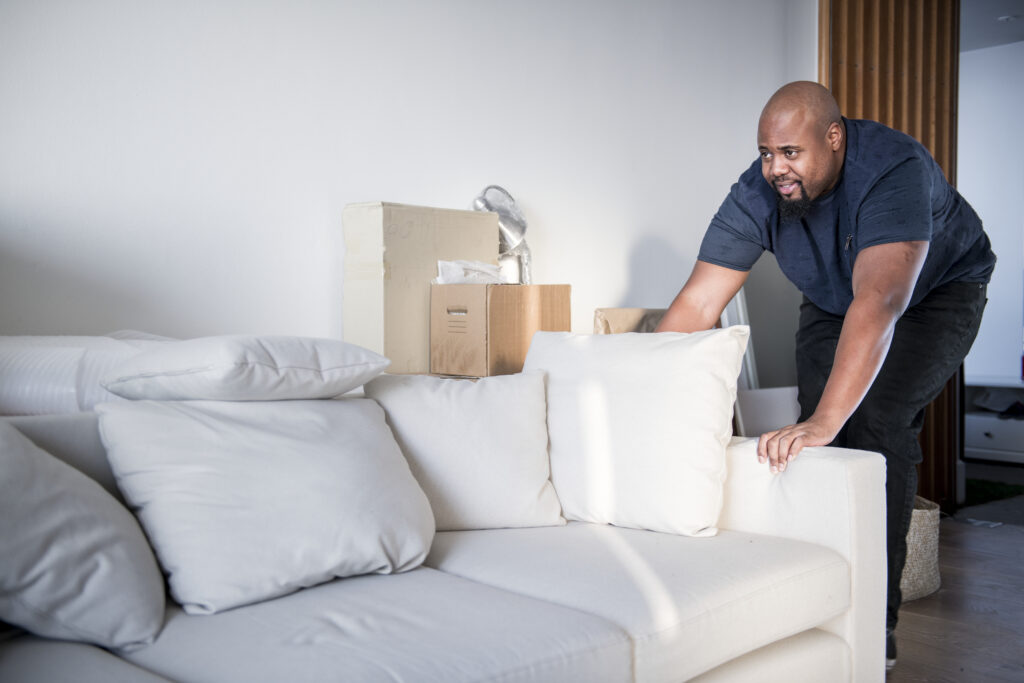 Courier setting up a couch in a customer's house